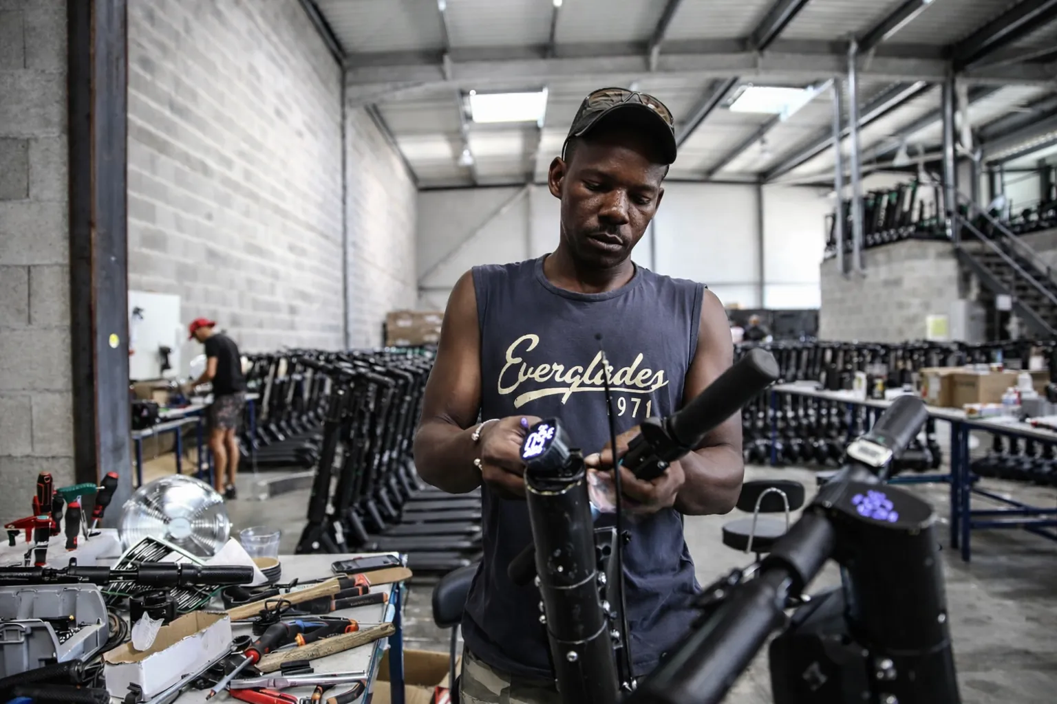 Agent reparant des trottinettes en entrepôt